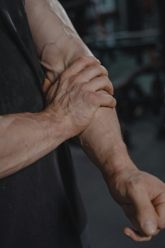 man gripping his forearm in pain